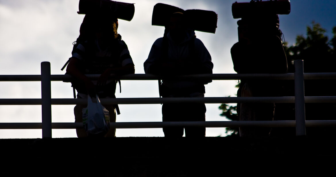 Three backpackers standing on a bridge