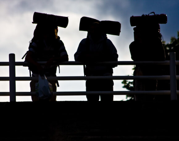 Three backpackers standing on a bridge