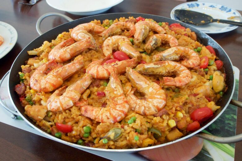 Large pan of paella topped with prawns