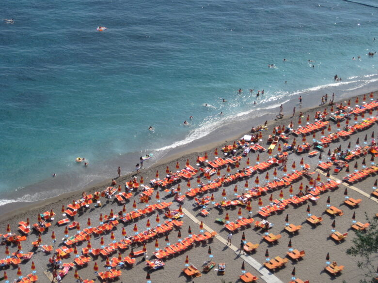 Rows of sun loungers and umbrellas on the beach in Positano