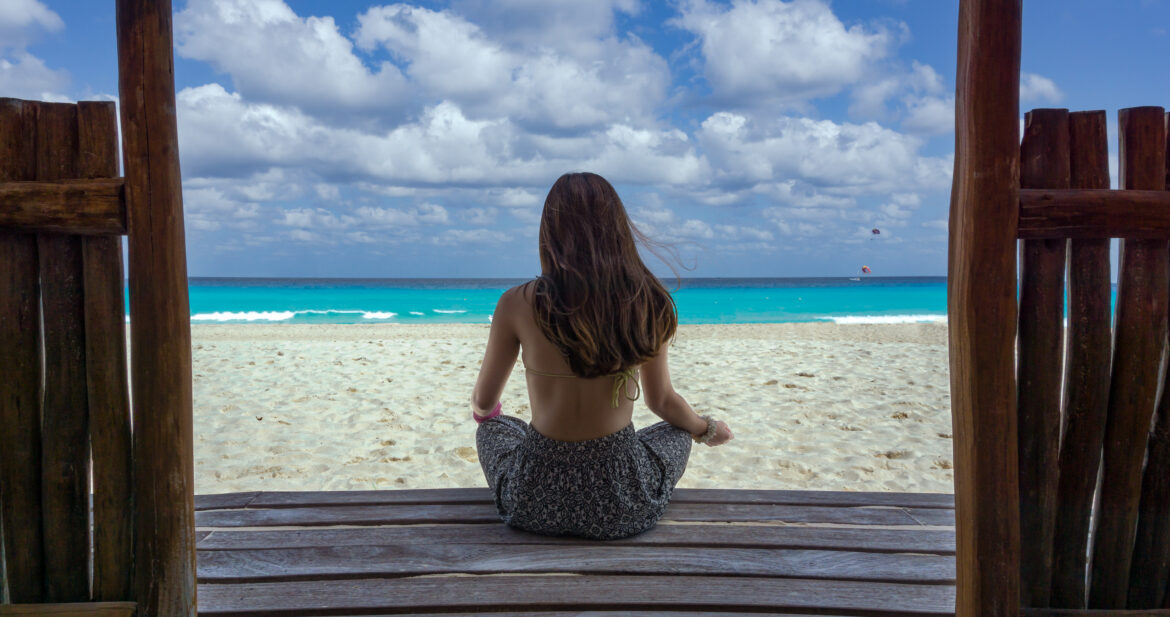 Woman sitting on a deck looking out to sea