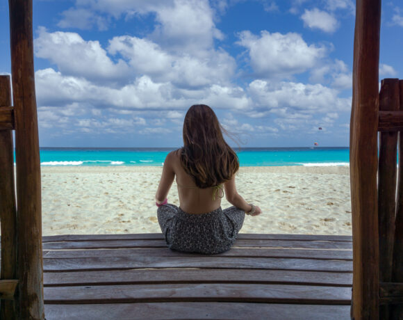 Woman sitting on a deck looking out to sea