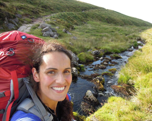 Women wearing a backpack while hiking in the countryside