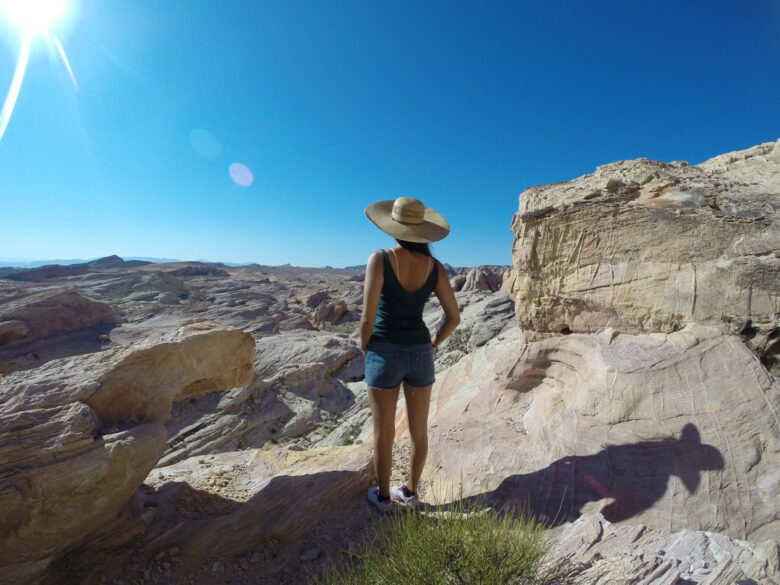 Woman stood admiring a sunny rocky landscape