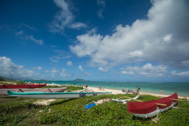 Kayaks and boats lined up along a beach in Hawaii