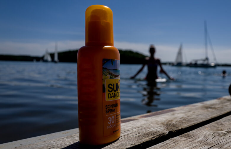 Bottle of sun cream on a wooden dock on a sunny day