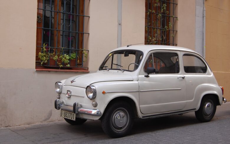 Small white vintage car in a street in Spain