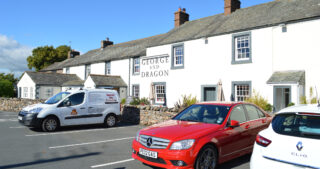 Cars parked outside of a country pub in England