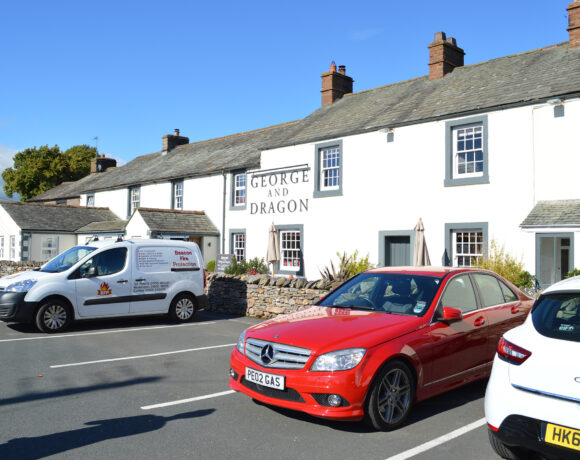 Cars parked outside of a country pub in England