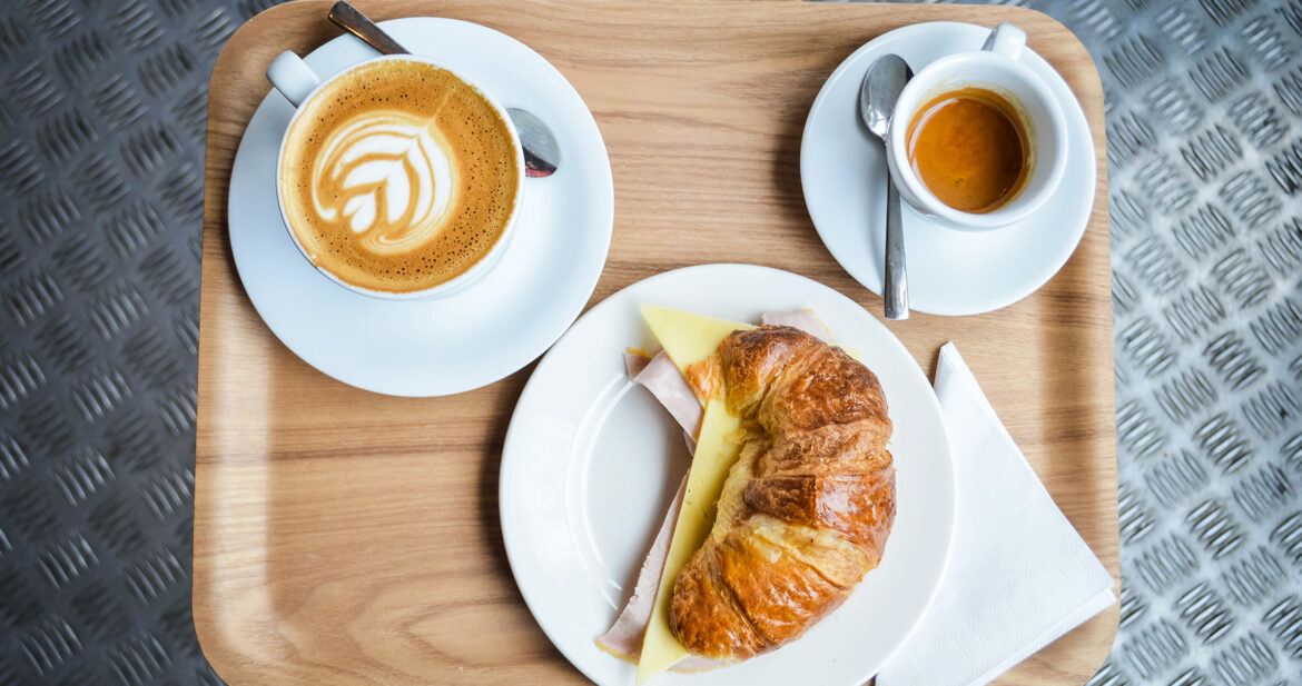 Tray with coffee, a filled croissant and an espresso