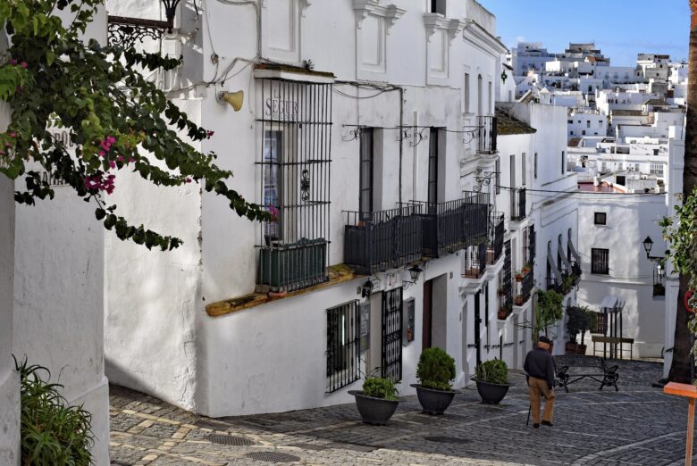 Man walking down the cobbled streets of a whitewashed Spanish village