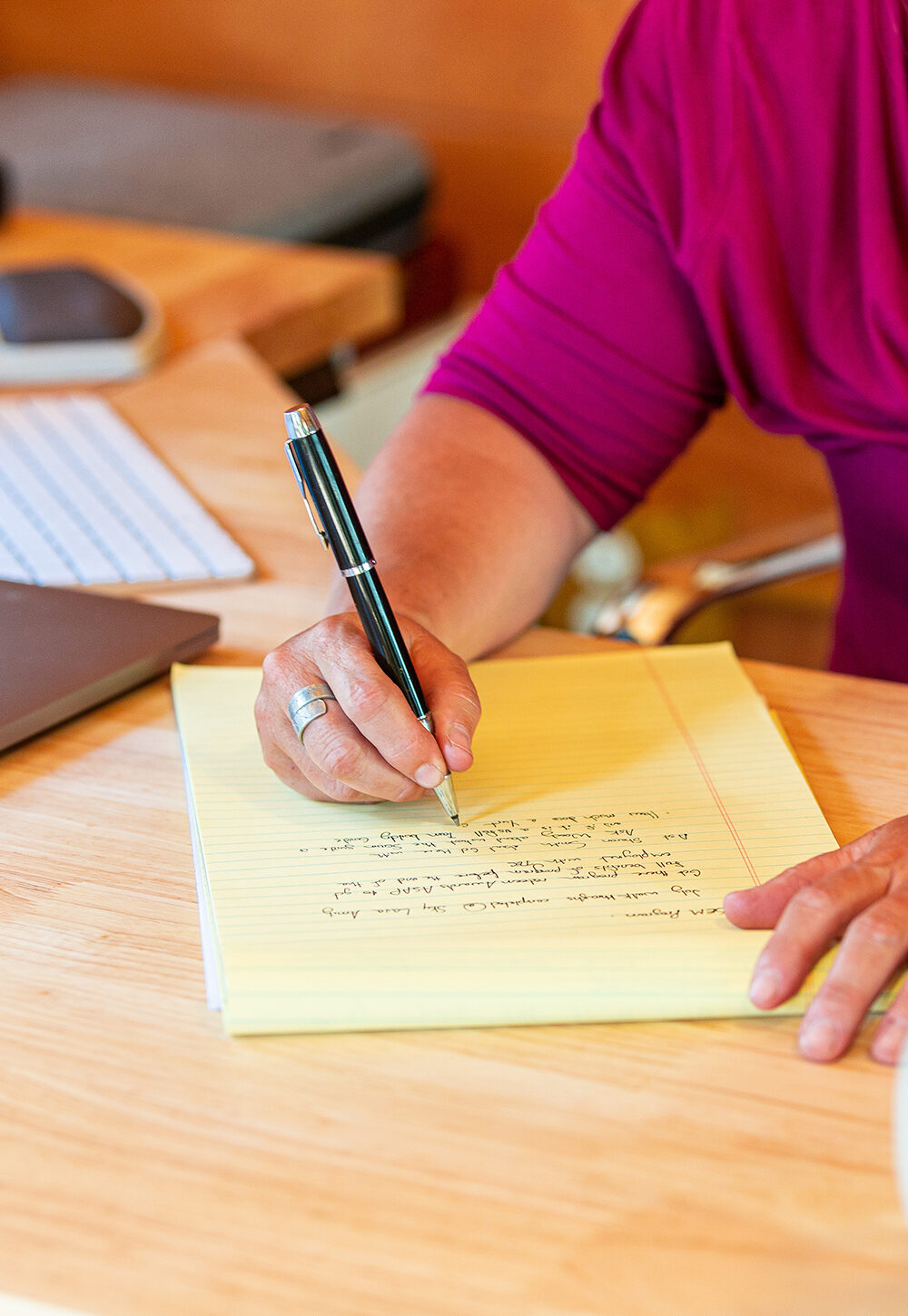 Women writing on a notepad on a remote working desk