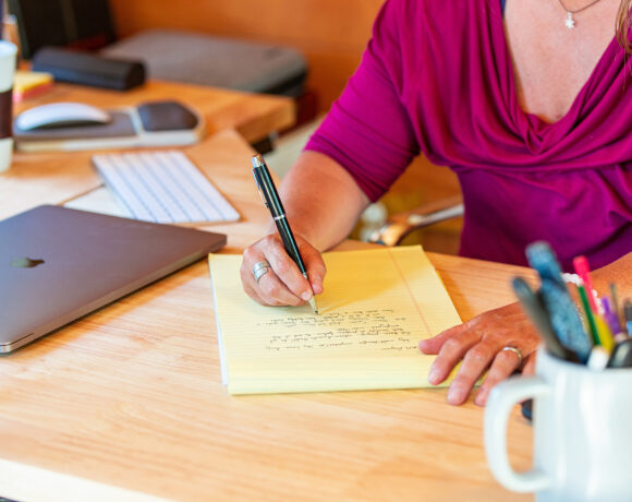 Women writing on a notepad on a remote working desk