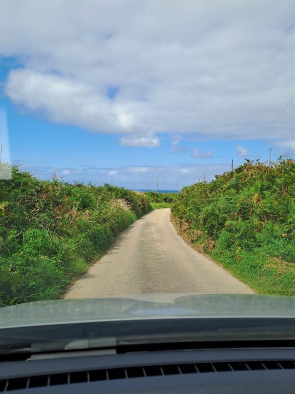 Car driving down a narrow road in the countryside